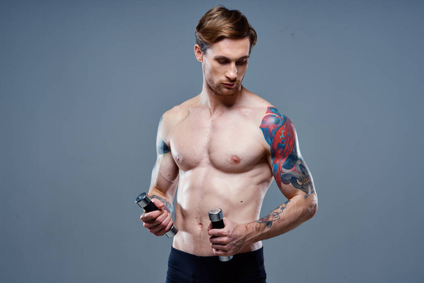 jóképű férfi szőke Sport Fitness szivattyúzott törzs súlyzó modell - Fotó, kép