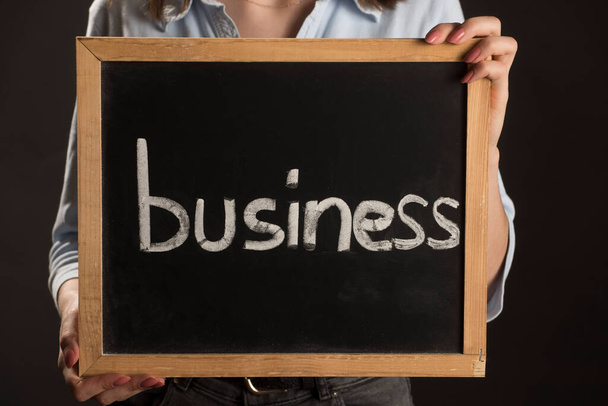 a person holding up a with the word business on it - Photo, Image