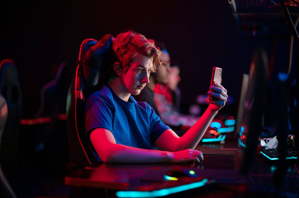 Een schattige gamer ging live op zenuwtrek van een smartphone en toont het trainingsproces van gamers in een computer club - Foto, afbeelding