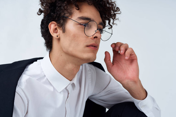 bel ragazzo in occhiali e in un abito classico su uno sfondo leggero ritratto close-up stile moda - Foto, immagini