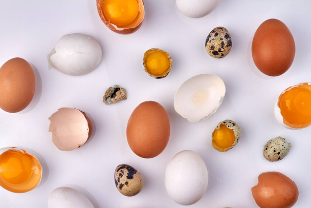 Muchas cáscaras de huevo agrietadas aisladas en blanco. - Foto, Imagen