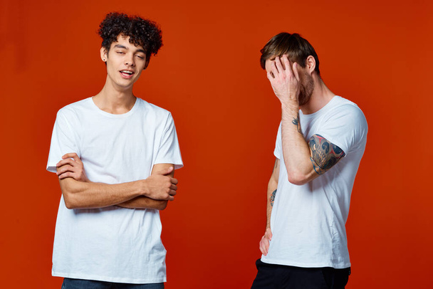 funny two men in white t-shirts on a red background friendship - Photo, Image