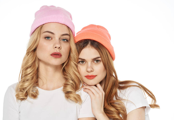 Two women in multi-colored caps cosmetics communication lifestyle glamor - 写真・画像