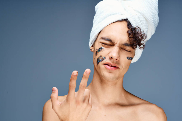 άνδρας με γυμνούς ώμους μαύρη μάσκα προσώπου κρέμα διαυγές δέρμα - Φωτογραφία, εικόνα