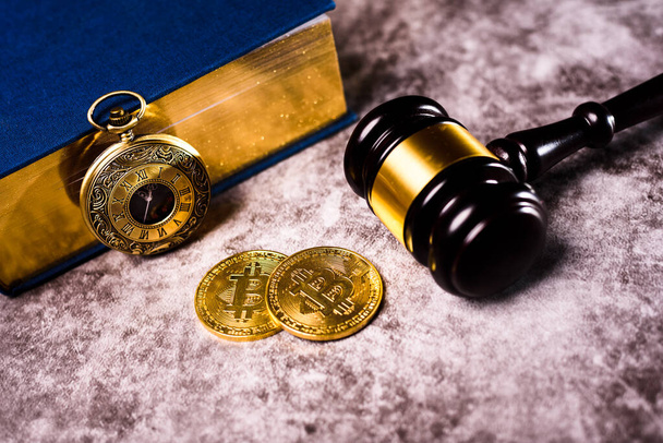 Bitcoin szabályozza a nemzetközi monetáris törvények, arany érme mellett kalapács. - Fotó, kép