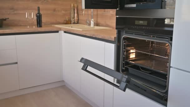 Širokoúhlý náklon záběr moderní bílé a dřevěné béžové kuchyně interiér - Záběry, video