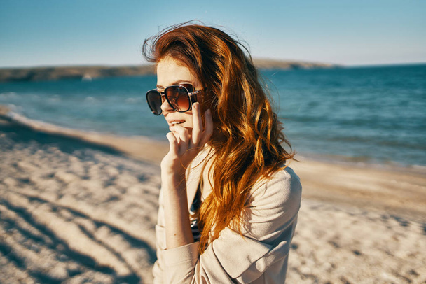 žena s brýlemi červené vlasy model béžový svetr úsměv moře pláž - Fotografie, Obrázek