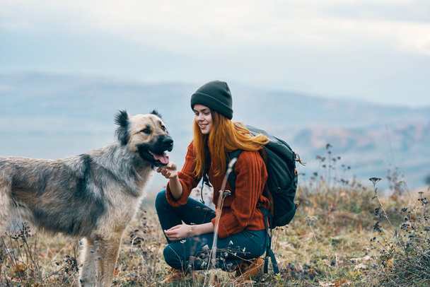 vidám nő túrázó sétáltatja a kutyát a természet a hegyekben táj - Fotó, kép