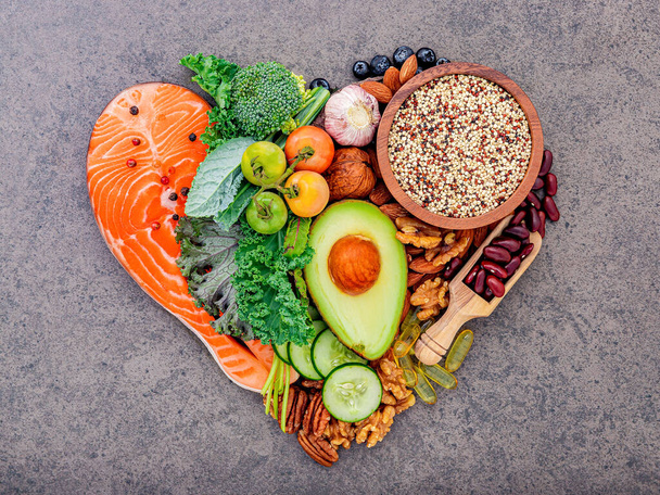 Heart shape of ketogenic low carbs diet concept. Ingredients for healthy foods selection on dark stone background. - Fotografie, Obrázek