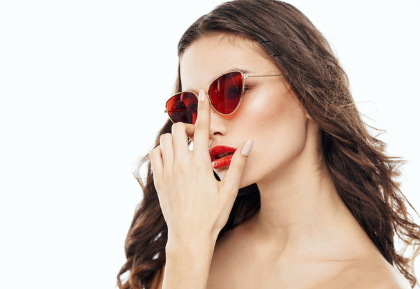 Attraktive Dame mit Sonnenbrille im Gesicht auf hellem Hintergrund - Foto, Bild