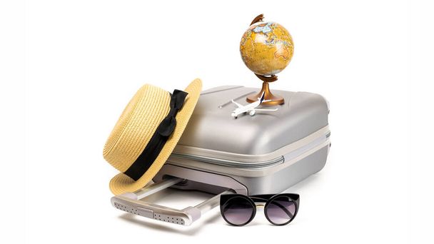 Summer pattern background. Suitcase, sunglasses with toy plane, straw hat and globe in travel composition isolated on white background. Design of summer vacation holiday with copy space - Photo, Image