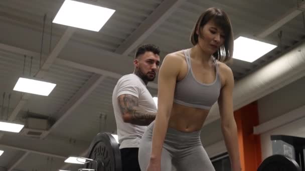 Sportovkyně trénink s osobním instruktorem v tělocvičně - Záběry, video