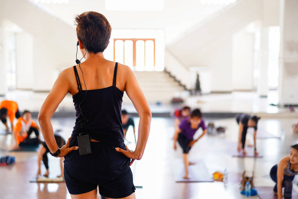 Grupa osób uprawiających jogę na zajęciach jogi w sali gimnastycznej, aby zrelaksować się i uzyskać zdrowe zdrowie. Sport i rekreacja Fotografia - Zdjęcie, obraz