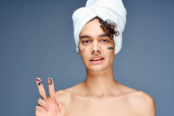 όμορφος άντρας με μια πετσέτα στο κεφάλι του γυμνός ώμοι καλλυντικά καθαρό δέρμα - Φωτογραφία, εικόνα