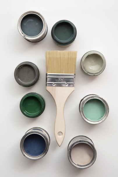 Overhead view of a DIY paint brush with trendy green sample paint pots - Fotoğraf, Görsel