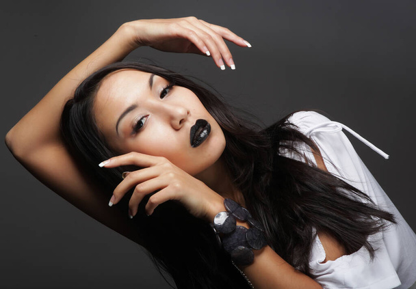 Beautiful young asian female model with black lips and long hair, wearing white bluse - 写真・画像