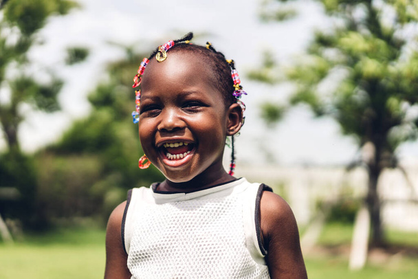 Портрет щасливої усміхненої маленької афроамериканської дівчинки в парку
 - Фото, зображення