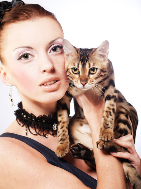 Beautiful stylish young woman dressed in retro style holding a cat - Fotoğraf, Görsel