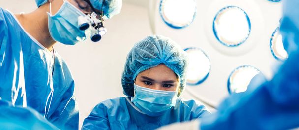 専門麻酔科医師チームと現代病院手術緊急治療室で手術機器を使用して手術を行う婦人科手術の患者を準備アシスタント - 写真・画像