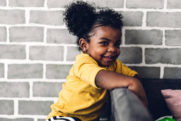 Portret van gelukkig lachend klein kind Afrikaans Amerikaans meisje thuis - Foto, afbeelding