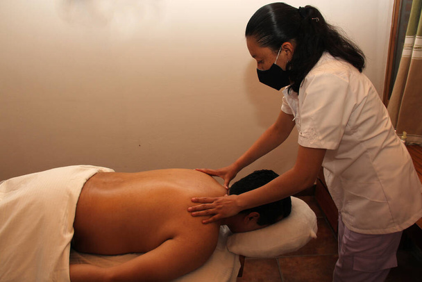 relajación en el spa. masajista trabajando en masaje relajante, reductivo y terapéutico para hombre latino - Foto, imagen