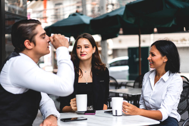 Group of cheerful young friend discussing meeting and talk enjoying their time drinking coffee together.Mixed race people sitting at cafe table and restaurant - 写真・画像