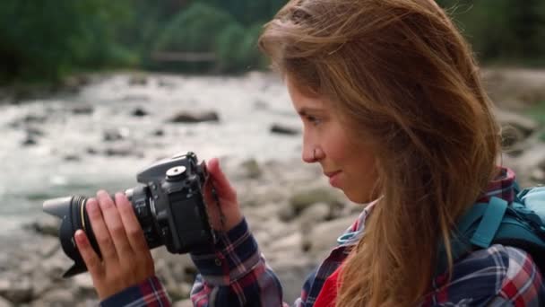 Fotograaf maakt foto 's van de natuur. Aantrekkelijke vrouw met fotocamera - Video