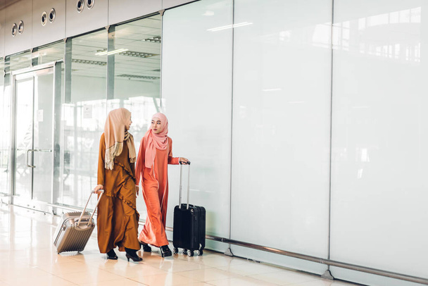 Two young asian muslim woman enjoying shopping and having fun talking together in the shop at fashion store - Photo, image