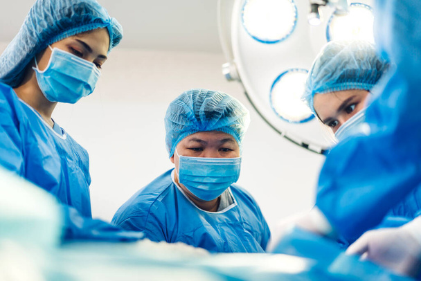 Ammattimainen anestesialääkäri lääkärin joukkue ja avustaja valmistelee potilasta gynekologiseen leikkaukseen, joka suorittaa leikkauksen nykyaikaisen sairaalan toiminnan ensiapupoliklinikalla - Valokuva, kuva