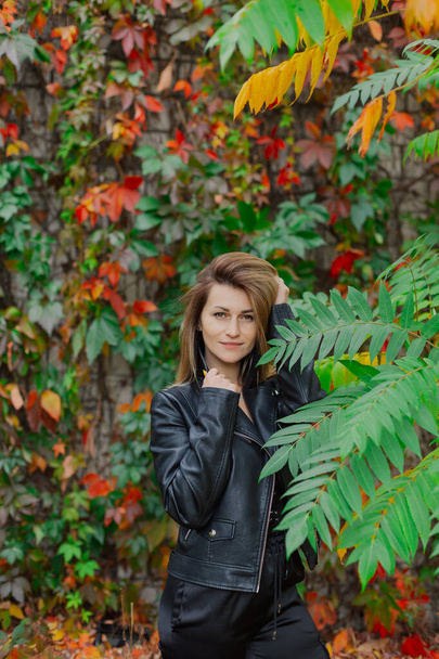 Beautiful portrait of a young woman in autumn bushes. - Fotó, kép