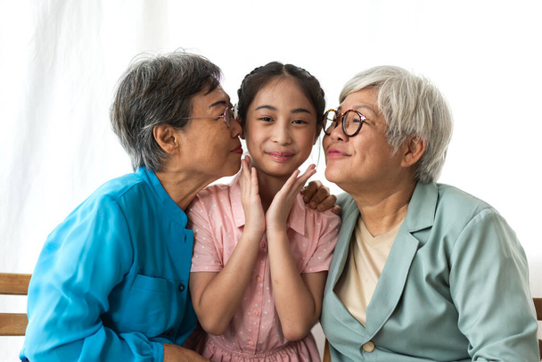Portré boldog ázsiai nagymama és kis ázsiai aranyos lány élvezze pihenni otthon.Fiatal lány a nevető nagyszülők mosolygott együtt.Család és összetartozás.Családi és együttlét - Fotó, kép