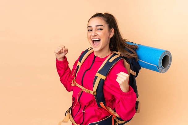 Mladý horolezec dívka s velkým batohem izolované na béžové pozadí - Fotografie, Obrázek