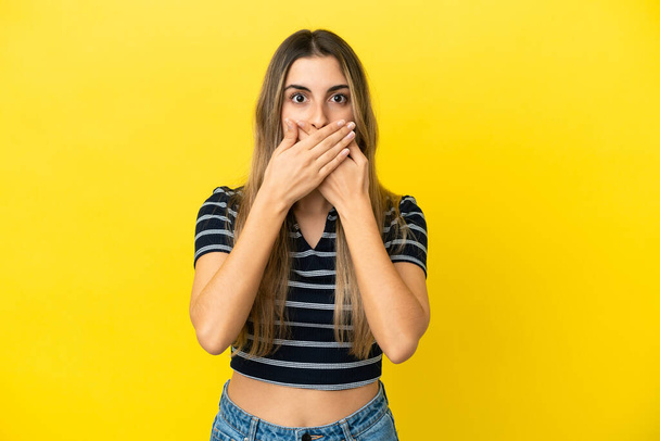 Fiatal fehér nő izolált sárga háttér borító száj kézzel - Fotó, kép