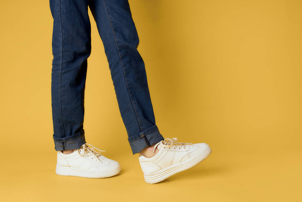 джинсы мода обувь белые кроссовки желтый фон - Фото, изображение