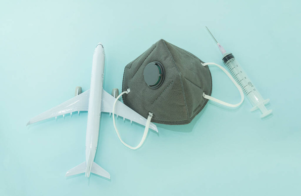 Repülőgép-modell, légzésvédő orvosi maszkok és egyszer használatos fecskendők.A koronavírus fogalma, COVID-19 világjárvány, globális karantén - Fotó, kép