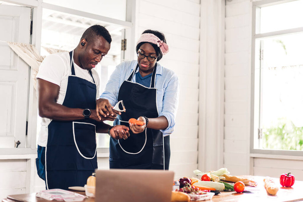 Portrait of love african american couple having fun cooking food together with fresh vegetable salad and sandwich ingredients to prepare the yummy eating in kitchen at home - Foto, Bild
