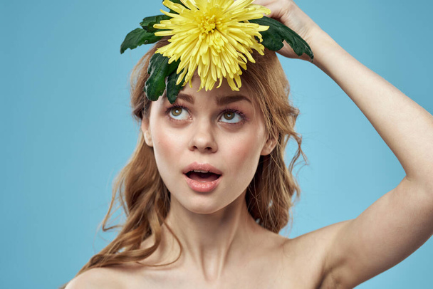 Krásná nahá žena ramena žlutý květ kouzlo modré pozadí - Fotografie, Obrázek