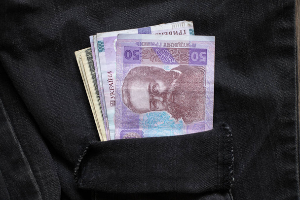 50 грн лежали в однім кармані чорних штанів зблизька, українські гроші - Фото, зображення