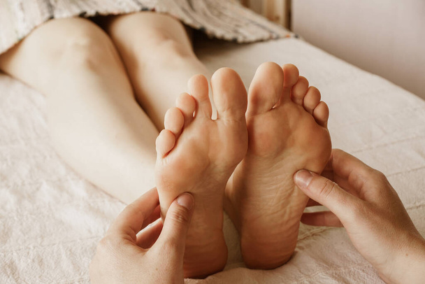 A closeup shot of masseur massaging a female's feet - Photo, image