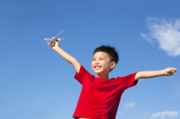 niño feliz sosteniendo un juguete de avión y brazos abiertos
 - Foto, Imagen