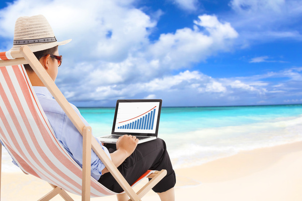 zakenman zittend op het strandstoelen en blik voorraad financiële - Foto, afbeelding