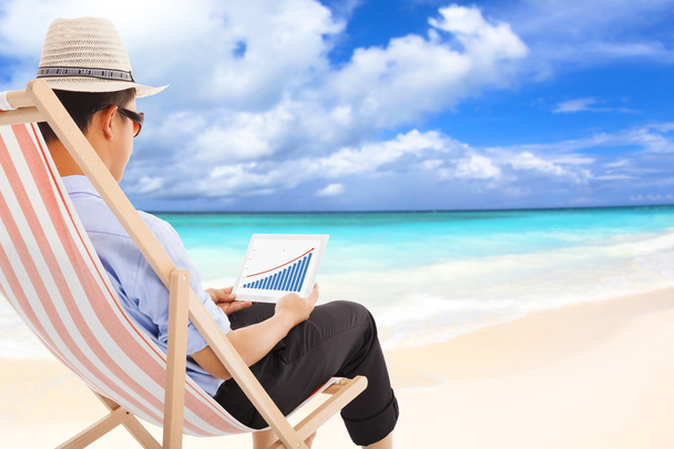 empresário sentado em cadeiras de praia e olhar estoque financeiro
 - Foto, Imagem