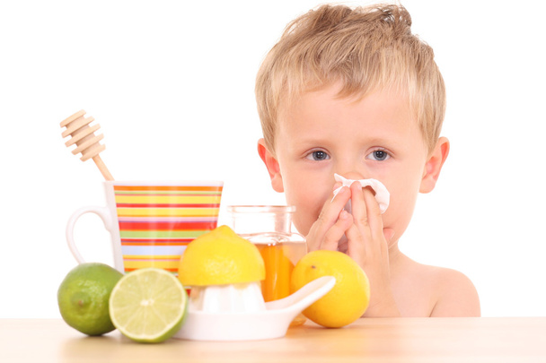 Garçon de 3-4 ans avec un remède contre le rhume et la grippe sur le blanc / accent sur l'enfant /
 - Photo, image