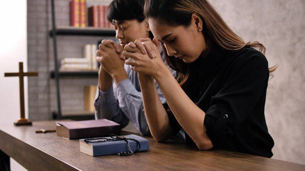 Nuori aasialainen kristitty pari rukoilee Jeesusta Kristusta kirkossa. - Valokuva, kuva