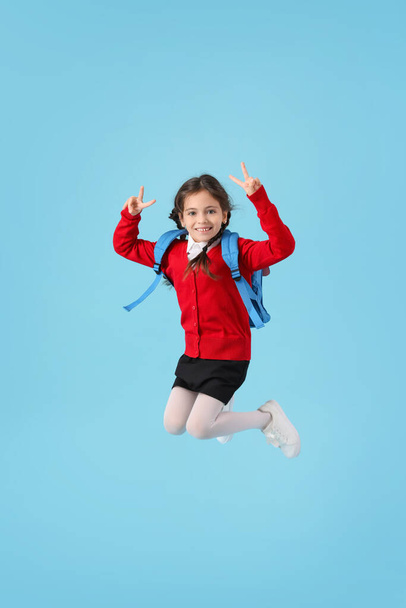 Hyppääminen pieni koulutyttö väri tausta - Valokuva, kuva
