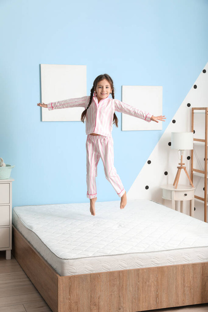 Funny little girl jumping on bed - Photo, image