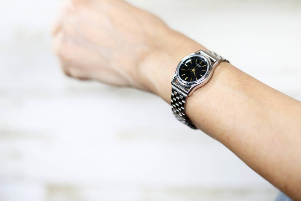 Kobieta nosząca srebrny zegarek nadgarstkowy - Zdjęcie, obraz