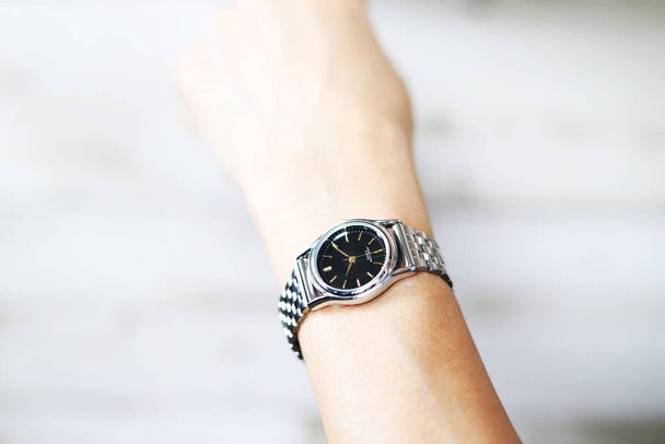 Frau trägt silberne Armbanduhr - Foto, Bild