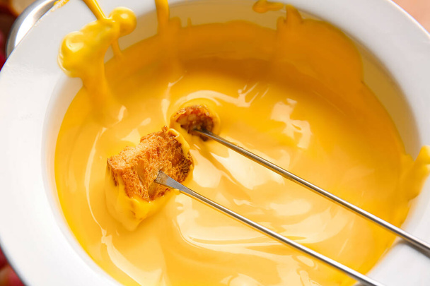 Palillo con crouton sumergido en fondue de queso, primer plano - Foto, Imagen