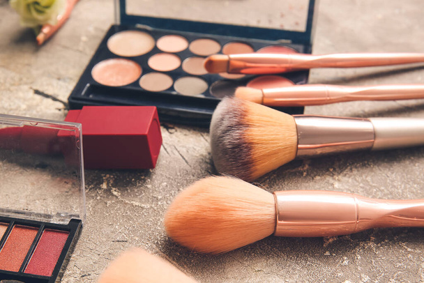 Pincéis de maquiagem e cosméticos em fundo cinza - Foto, Imagem